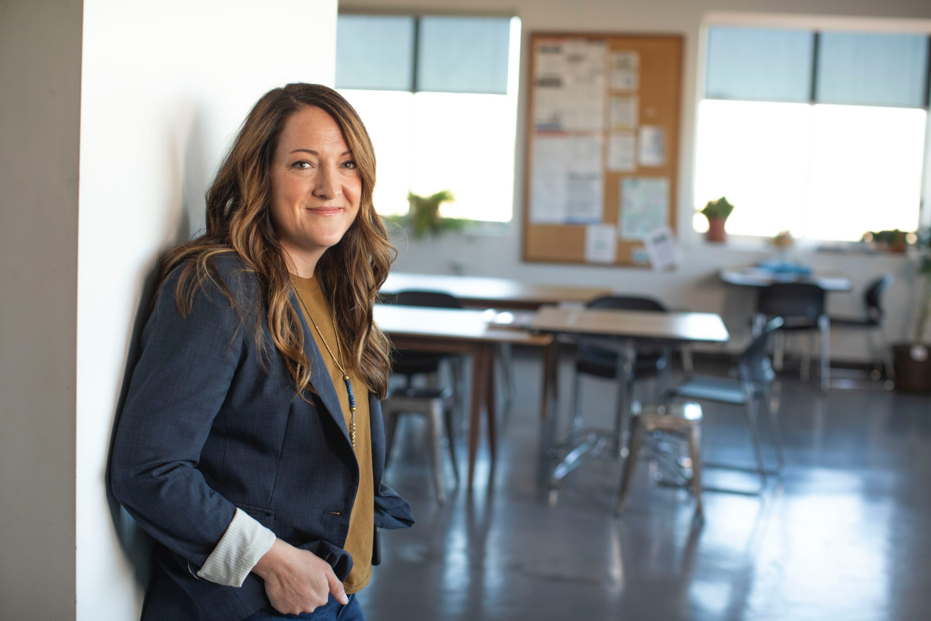 A teacher standing just outside an empty classroom.